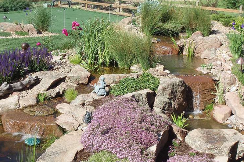 large water falls and stream with putting green and landscaping